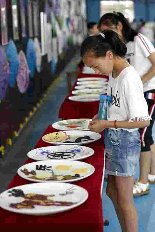 主赛场参赛的同学们观看现场展出的象棋主题五谷画